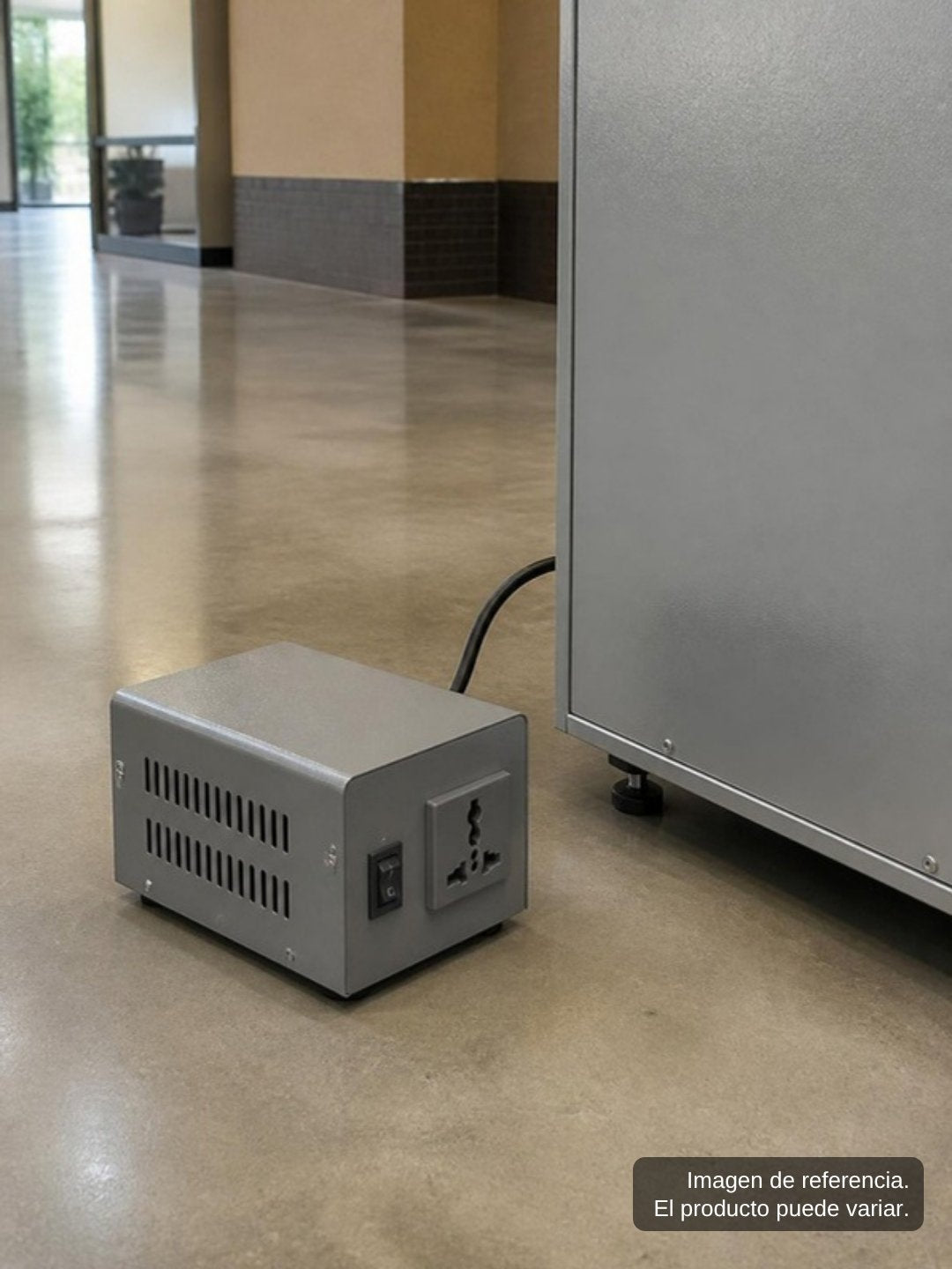 Adaptador de corriente de 220 V a 110 V junto a una máquina expendedora en interior