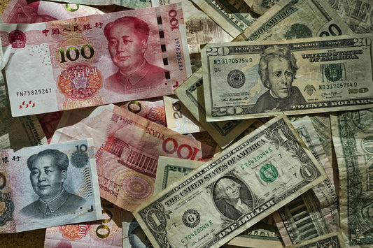Billetes de 100 yuanes y de dólares estadounidenses sobre una mesa