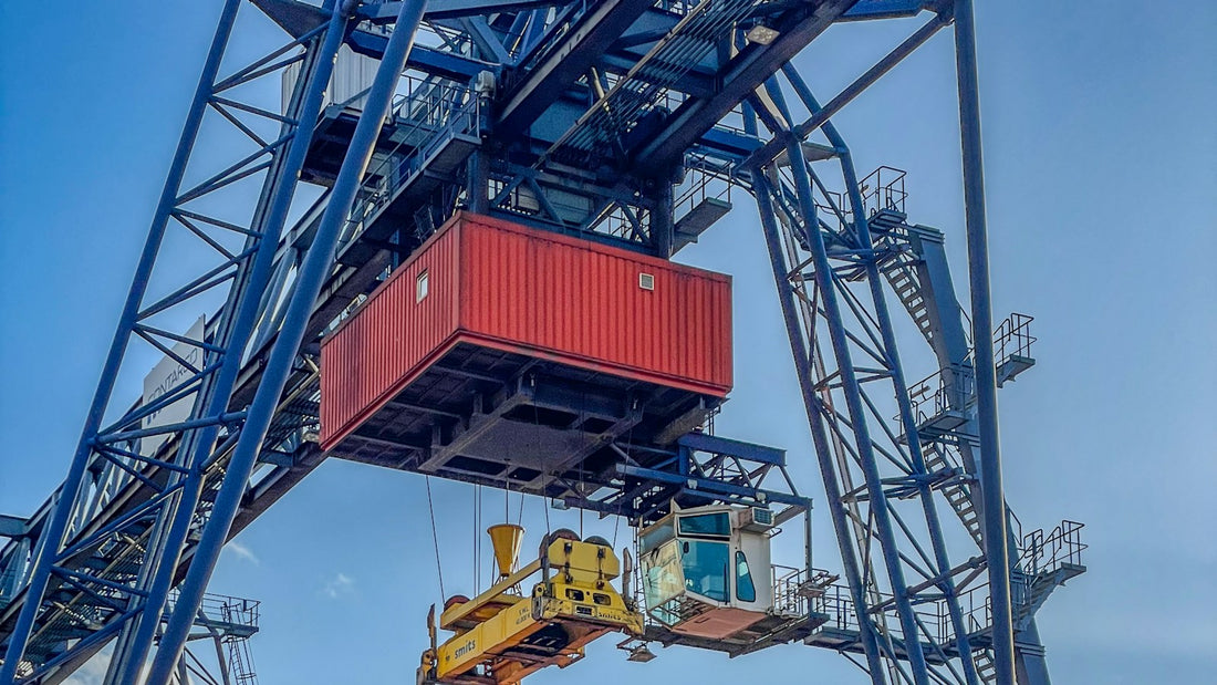 Grúa portacontenedores carga un contenedor en un camión en una terminal