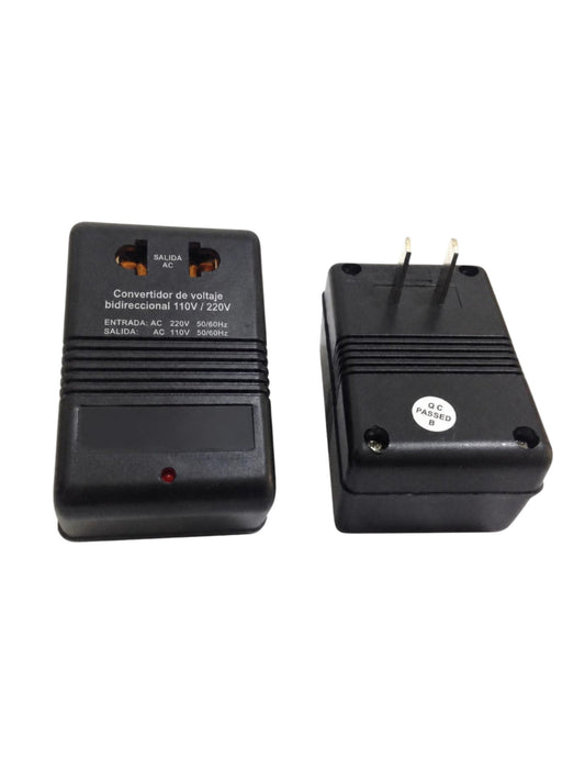 Convertidor de voltaje bidireccional 110 V / 220 V en carcasa negra, vista frontal con contactos y vista trasera con clavija, en fondo blanco