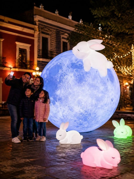Inflable retroiluminado gigante en un festival nocturno en Puebla, familias tomándose fotos