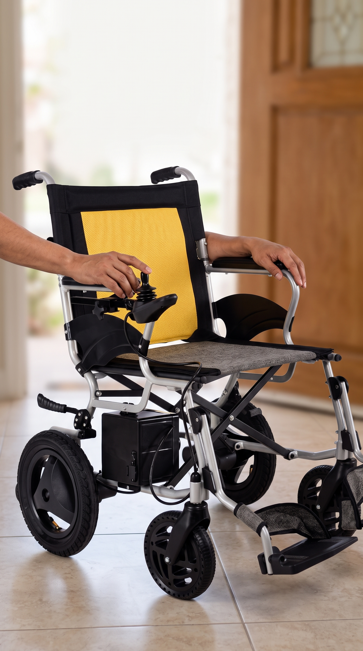 Silla de ruedas eléctrica plegable de 19 kg con respaldo amarillo y control de joystick, dentro de una casa