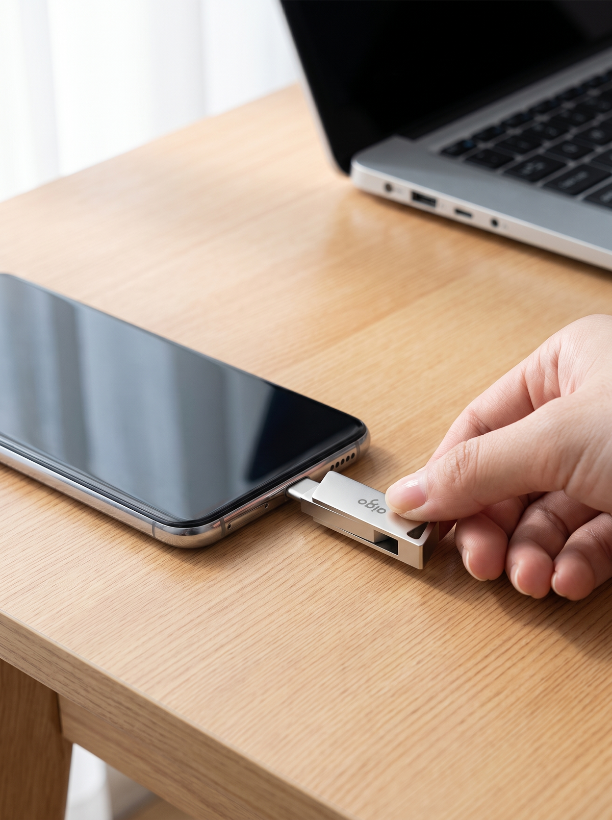 Memoria USB doble puerto conectada a un celular sobre un escritorio de madera