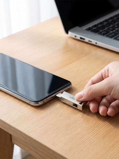 Memoria USB doble puerto conectada a un celular sobre un escritorio de madera