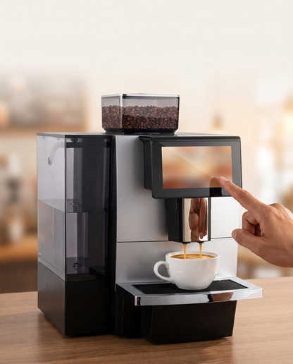Dedo tocando la pantalla de la cafetera superautomática mientras sirve un espresso