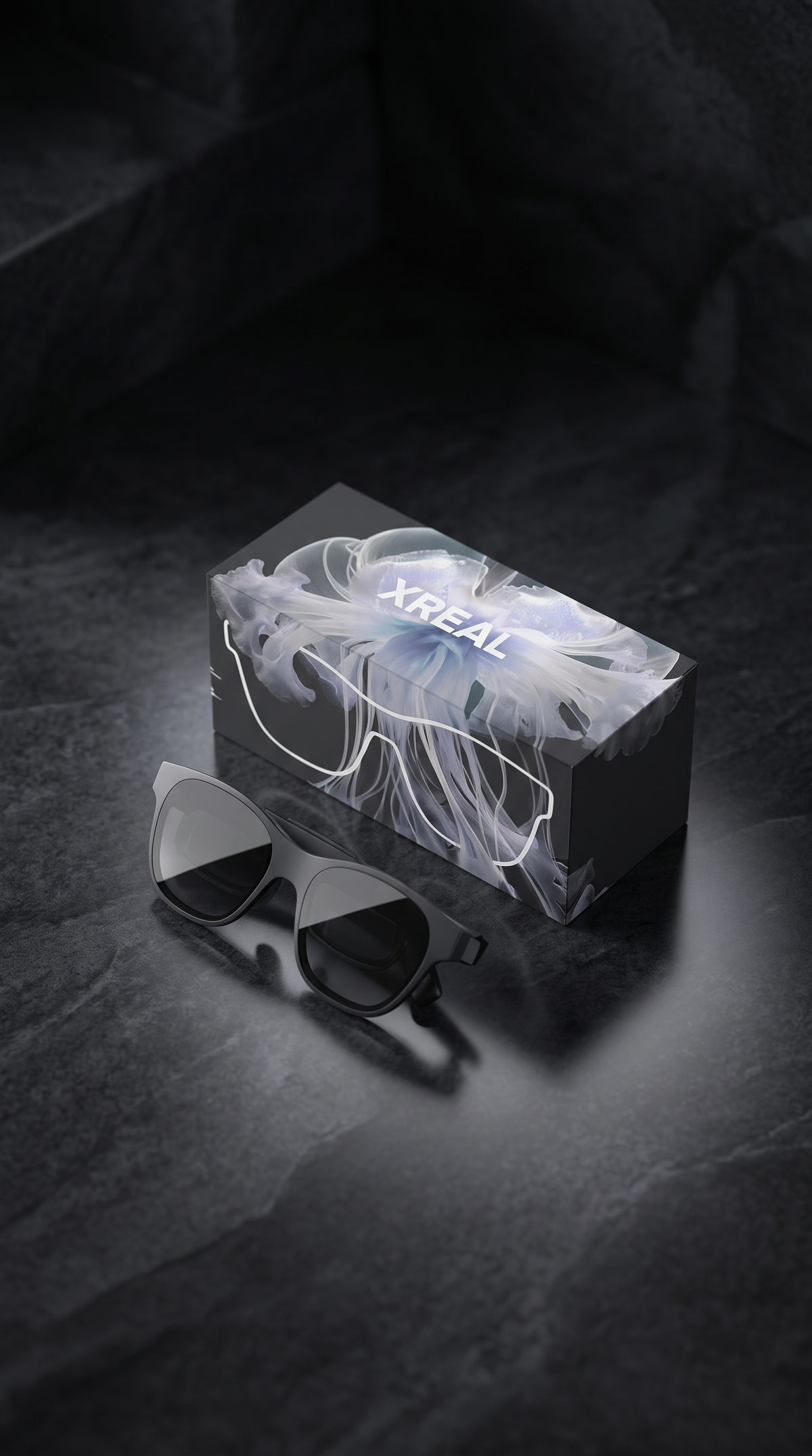 Lentes de realidad aumentada junto a su caja sobre una superficie de piedra negra