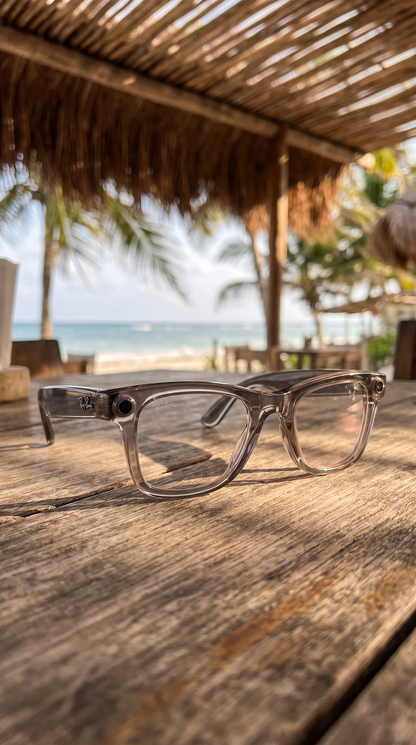 Lentes inteligentes con cámara sobre una mesa de madera en una palapa frente al mar