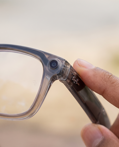 Mano sosteniendo los lentes inteligentes mostrando la cámara integrada